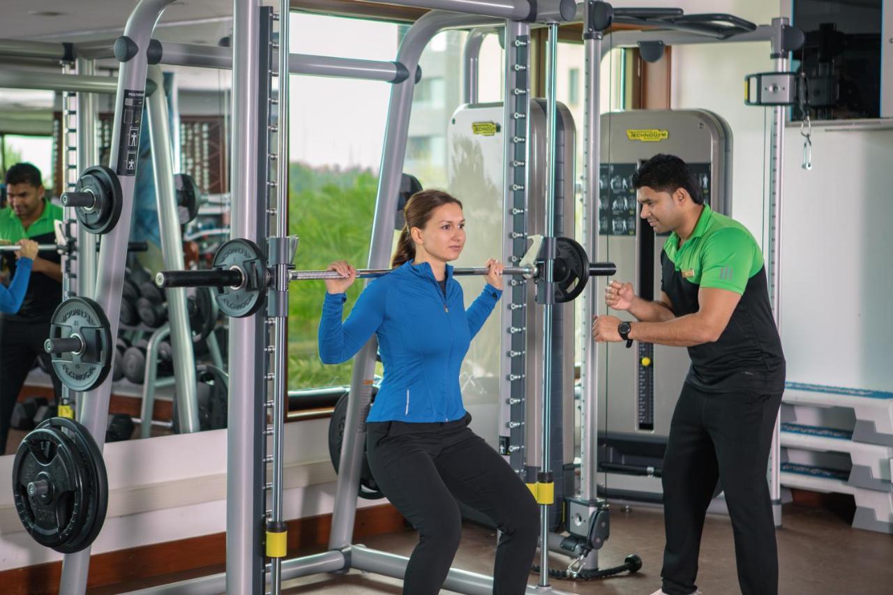 Jumeirah Messilah Beach Kuwait Kuwait City Екстер'єр фото A personal trainer assisting a woman with a squat