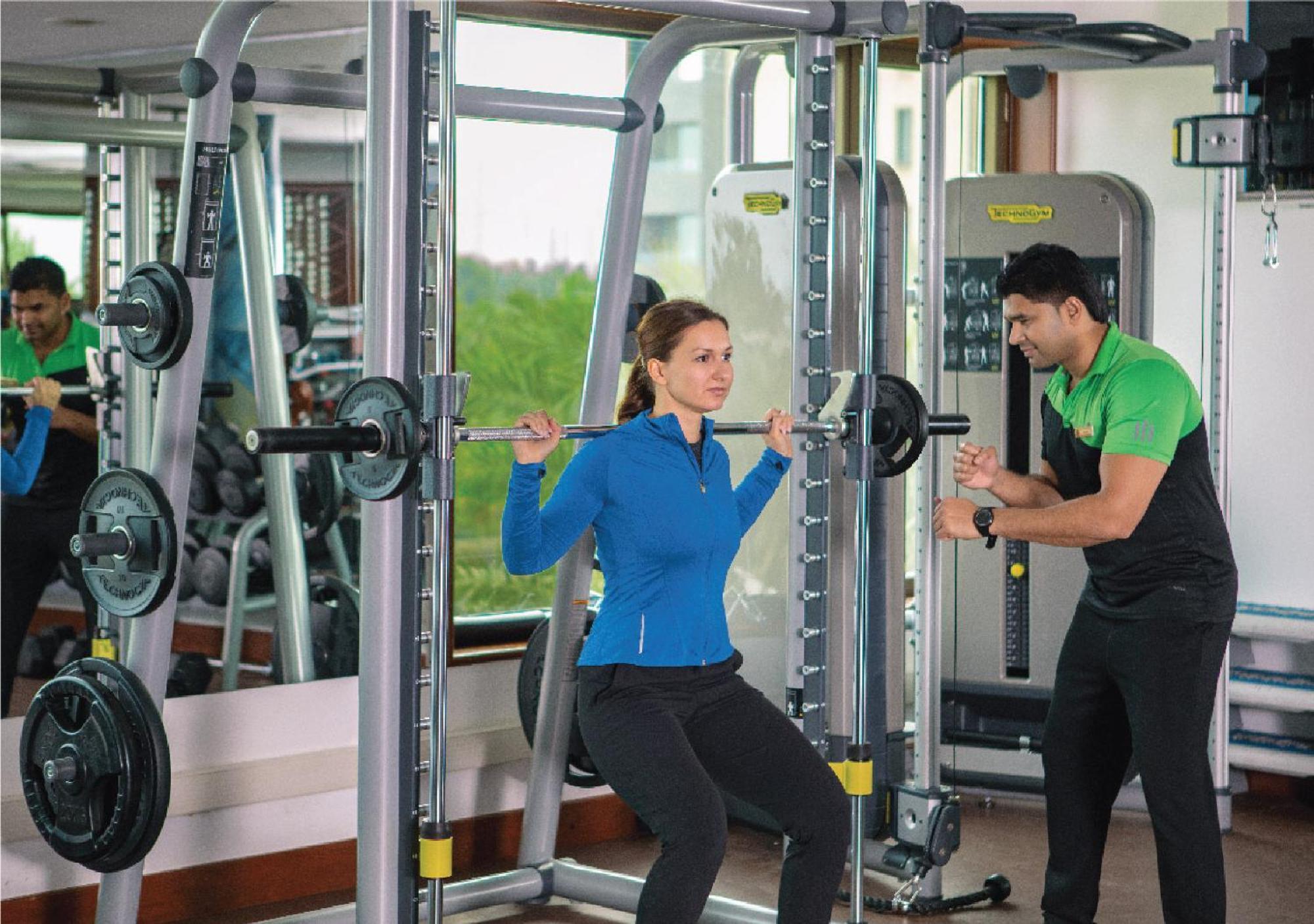 Jumeirah Messilah Beach Kuwait Kuwait City Екстер'єр фото A personal trainer assisting a woman with a weight training exercise